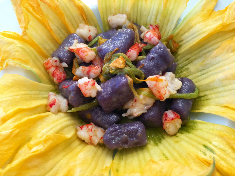 gnocchi di patate viola ai gamberi rossi e fiori di zucchina